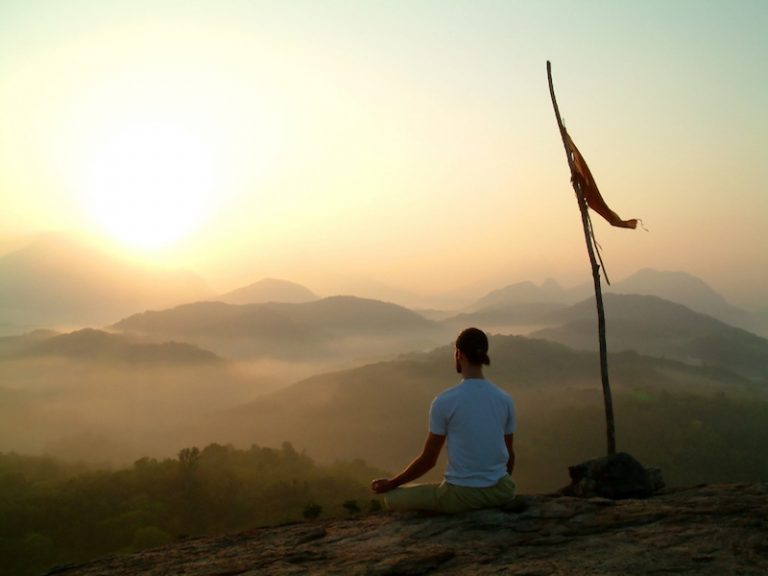 man meditating at sunrise